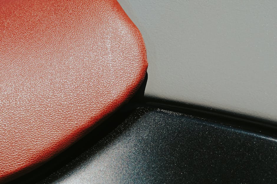 Detailed close-up showing the texture of a red leather seat, emphasizing the rich material.